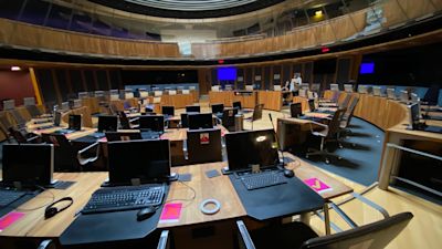 The chamber is marked out for social distancing. Chairs are reserved for specific members.