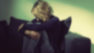 Woman crouching on a sofa.