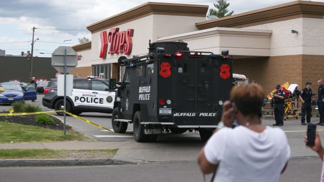 A crowd gathers as police investigate after a shooting at a supermarket on Saturday, May 14, 2022, in Buffalo, N.Y. Multiple people were shot at the Tops Friendly Market. Police have notified the public that the alleged shooter was in custody. 