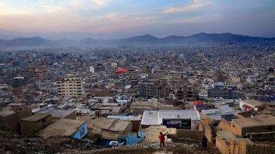 A young boy flies a kite over the outskirts of Kabul, Afghanistan.