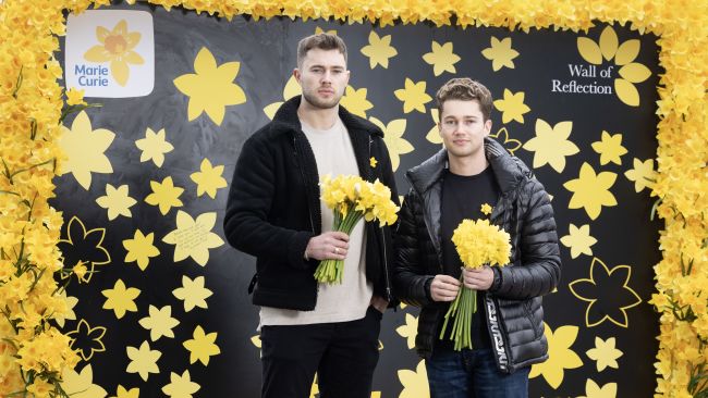 EDITORIAL USE ONLY Curtis (left) and AJ Pritchard write a message on end-of-life care charity Marie Curie's Wall of Reflection on London's South Bank ahead of the third annual National Day of Reflection on Thursday. Issue date: Wednesday March 22, 2023.

