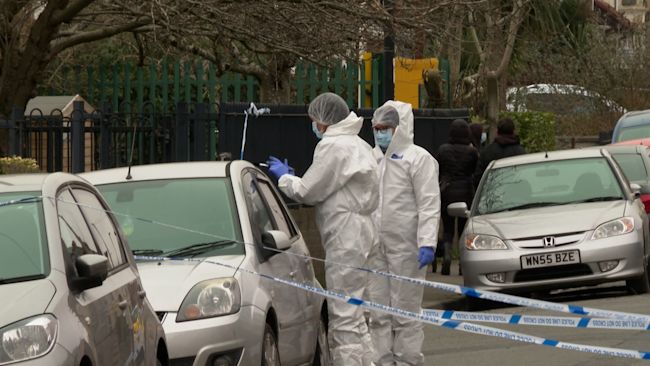 Police forensic beside car at crime scene