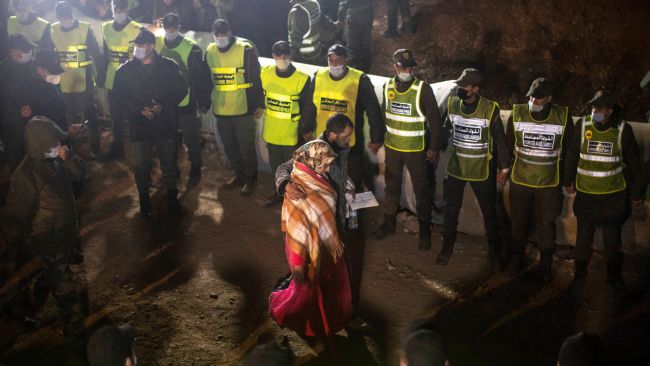 Parents of 5-year-old Rayan walk towards the tunnel as their son's body was being retrieved, after he fell into a hole and was stuck there for several days