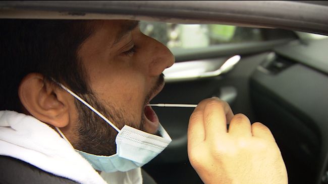 A man takes a lateral flow coronavirus test before entering the mosque.