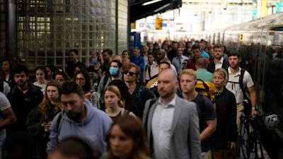 Passengers disembark from one of the few trains to arrive this morning at Waterloo railway station in London