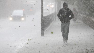 A man walks along the Harrow Road, west London, during as hail storm