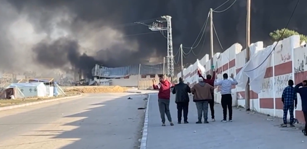 Ramzi Abu Sahloul was among a group of five males standing still, their hands up, one of them brandishing a white flag.