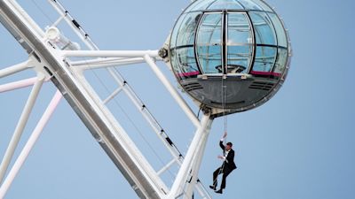 A man dressed as Britain's most famous secret service agent, James Bond, hangs from a pod on the lastminute.com London Eye, the landmark tourist attraction in central London, ahead of the world premiere of No Time To Die, the latest instalment in the Bond franchise. Picture date: Tuesday September 28, 2021.