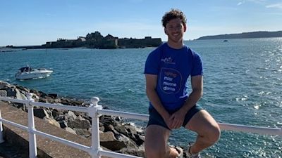 Max Renouf-Watkins wears his MNDA tshirt by the sea.