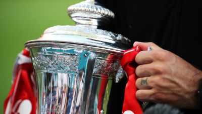 Close up image of the Emirates FA Cup in the hands of Arsenal manager Mikel Arteta