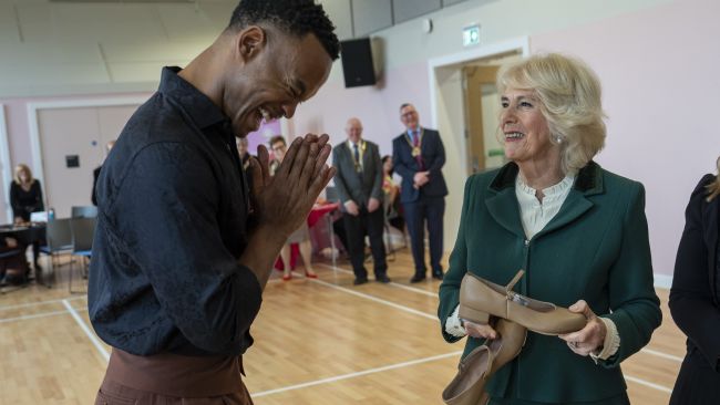 Queen Camilla is presented with a pair of tap shoes by dancer Johannes Radebe (left) during a visit to the newly opened Meadows Community Centre in Cambridge in her role as President of the Royal Voluntary Service. Picture date: Friday February 2, 2024.
Credit: PA