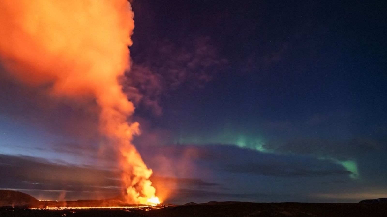 Photo shows Northern Lights dancing over erupting volcano in Iceland