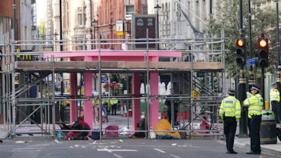 Workers remove part of a large pink strcture that had been used by environmental activists from Extinction Rebellion to block the junction of Long Acre and Upper St Martin's Lane in London.