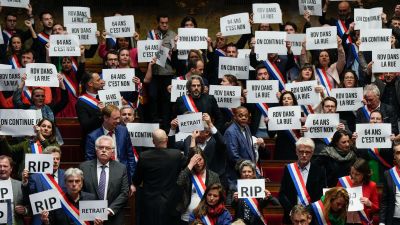 Far-left lawmakers hold papers reading: "64 years. It is no", "appointment in the street", "we are continuing", at the National Assembly in Paris.