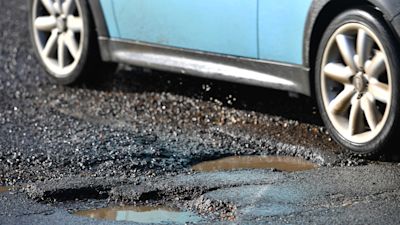 A car passes a pothole