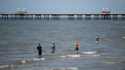 People enjoy the warm weather by participating in activities on Blackpool beach