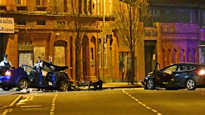 Police at the scene of the crash on the Ravenhill Road, which killed two people and injured five. Pic Alan Lewis.