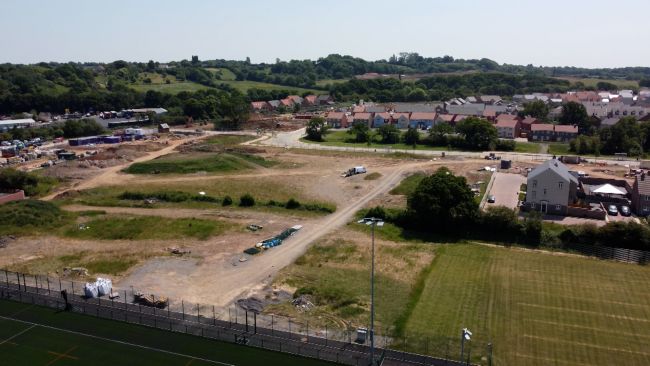 Drone shot of building site in Lyde Green where schools should be