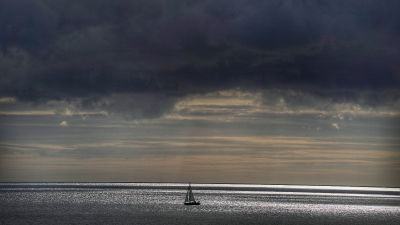 Storm clouds gather over a sail boat in the North Sea.