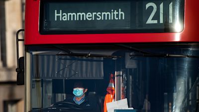 A London bus driver wearing a protective face mask on Westminster Bridge, London, after Prime Minister Boris Johnson made the decision to put the UK in lockdown to help curb the spread of the coronavirus.
