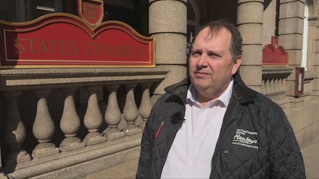 A photo of Robert Surcouf standing outside of the States Chamber.