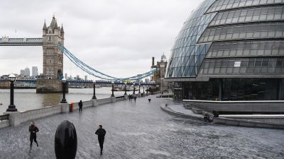 People jog along the riverside path past Tower Bridge and City Hall in London. Picture date: Thursday January 28, 2021.