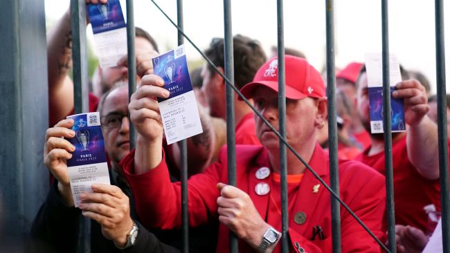 Liverpool fans stuck outside the ground show their match tickets