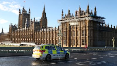 A police car on Westminster bridge by the Houses of Parliament in London. Millions more people moved to harsher coronavirus restrictions as the new tier changes came into force in England.