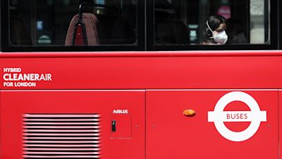 A person wearing a face mask rides a bus on Piccadilly, London, following the introduction of measures to bring England out of lockdown.