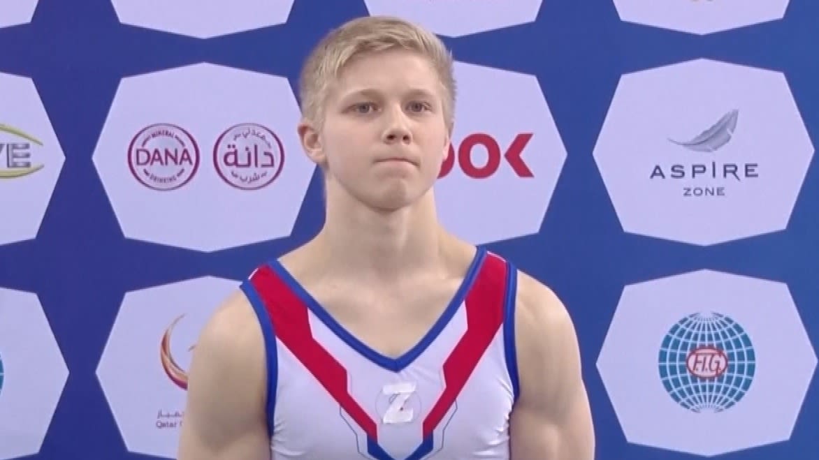 Russian gymnast stands on the podium with symbol supporting