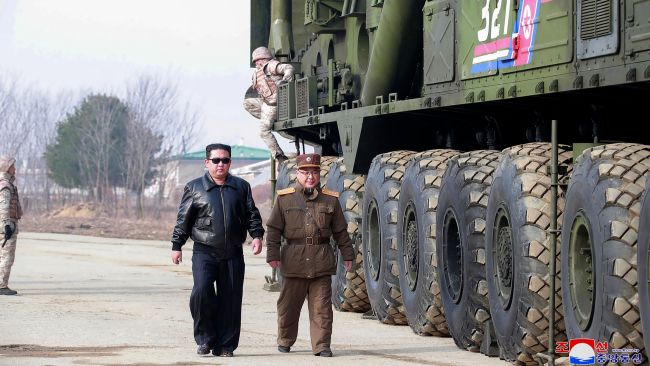 In this photo distributed by the North Korean government, North Korean leader Kim Jong Un, center left, walks around what it says a Hwasong-17 intercontinental ballistic missile (ICBM) on the launcher, at an undisclosed location in North Korea on March 24, 2022. Independent journalists were not given access to cover the event depicted in this image distributed by the North Korean government. The content of this image is as provided and cannot be independently verified. Korean language watermark on image as provided by source reads: "KCNA" which is the abbreviation for Korean Central News Agency. (Korean Central News Agency/Korea News Service via AP)


