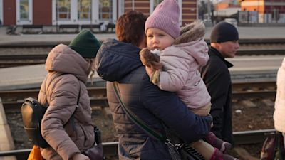 Caption/Description: A woman carries a baby as she arrives to board a Kyiv bound train, on a platform in Kramatorsk, the Donetsk region, eastern Ukraine, Thursday, Feb. 24, 2022. Russian President Vladimir Putin on Thursday announced a military operation in Ukraine and warned