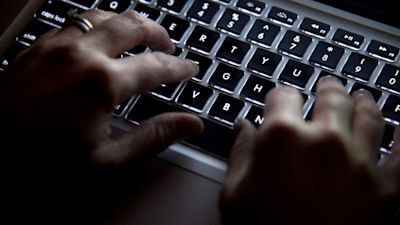 Hands typing on a laptop keyboard