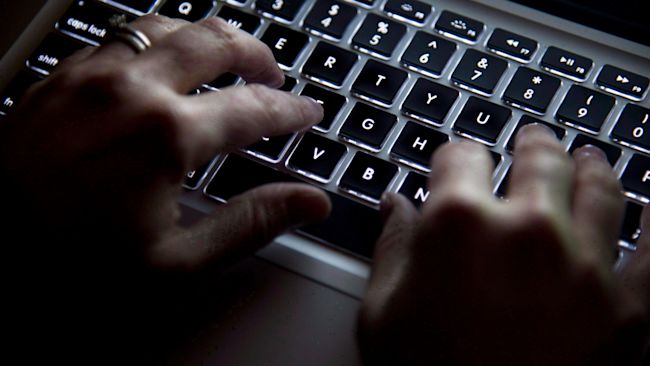 Hands typing on a laptop keyboard