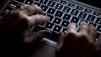 Hands typing on a laptop keyboard