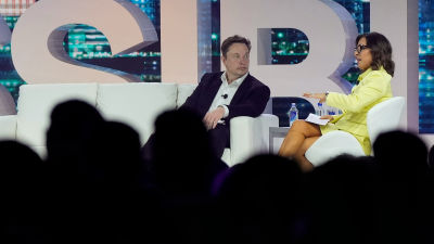 Elon Musk speaks with Linda Yaccarino in April 2023.