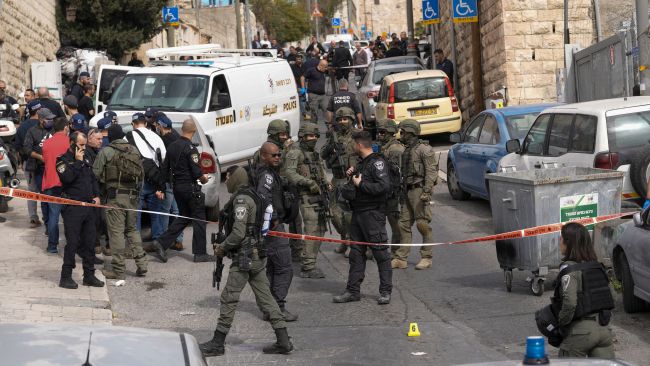 An Israeli policeman secures a shooting attack site in east Jerusalem, Saturday, Jan. 28, 2023. A Palestinian gunman opened fire in east Jerusalem on Saturday, wounding at least two people less than a day after another attacker killed seven outside a synagogue there in the deadliest attack in the city since 2008. (AP Photo/Mahmoud Illean)