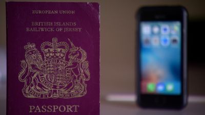 A physical passport and phone.