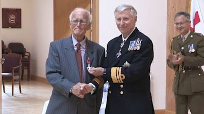 Dr Richard Axton is presented with his MBE.