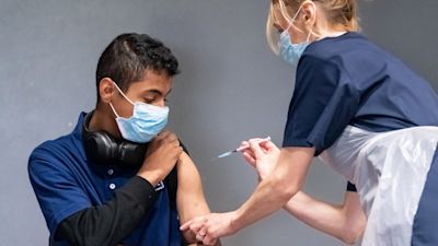 Nurse Sonia Wilson (right) vaccinates eighteen-year-old Cameron Ladd (left) with the Pfizer Covid-19 vaccination, at a mass coronavirus vaccination centre at Adwick Leisure Centre, in Doncaster, as the NHS �Grab a jab� vaccine drive continues in England. Picture date: Sunday June 27, 2021.