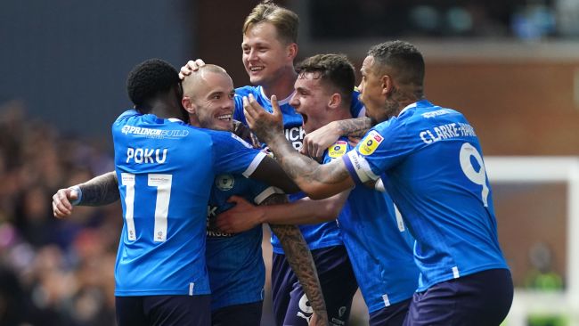 Joe Ward celebrates scoring for Peterborough United with his teammates. 