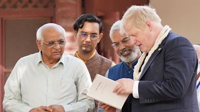 Boris Johnson is shown a copy of Guide to London, which was written by Mahatma Gandhi but never published