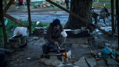 A man cooks on an outdoors stove in Ukraine.