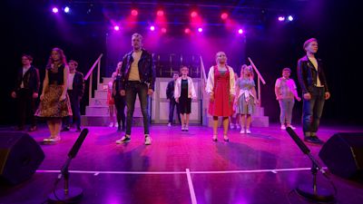 The stage and cast of Grease.