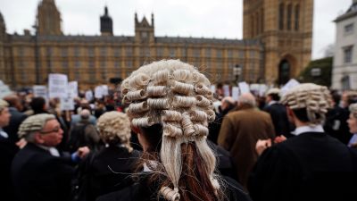 Lawyers in their full court dress of wigs and gowns, participate in a rally to protest against legal aid cuts, across from the Houses of Parliament in central London, Friday, March 7, 2014. The protest coincides with a nationwide demonstration of non-attendance of lawyers which will affect hundreds of cases across the country.