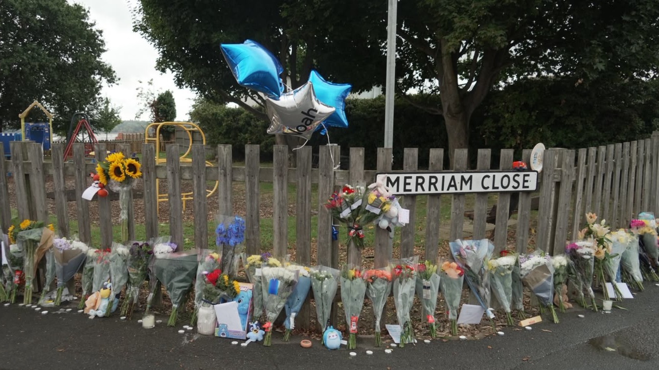 Flowers and balloon tributes next to a fence after emergency service workers found the body of missing boy Noah Woods. 