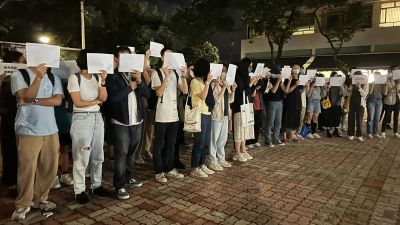 Protesters hold up blank white papers during a commemoration for victims of a recent Urumqi deadly fire at the Chinese University of Hong Kong in Hong Kong, Monday, Nov. 28, 2022. Students in Hong Kong chanted “oppose dictatorship” in a protest against China’s anti-virus controls after crowds in mainland cities called for President Xi Jinping to resign in the biggest show of opposition to the ruling Communist Party in decades. Credit: AP