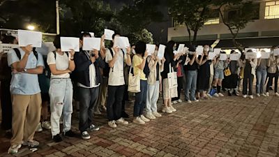 Protesters hold up blank white papers during a commemoration for victims of a recent Urumqi deadly fire at the Chinese University of Hong Kong in Hong Kong, Monday, Nov. 28, 2022. Students in Hong Kong chanted “oppose dictatorship” in a protest against China’s anti-virus controls after crowds in mainland cities called for President Xi Jinping to resign in the biggest show of opposition to the ruling Communist Party in decades. Credit: AP