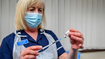 Nurse Tina Sutton draws off a single dose from a vial, which can provide 10 individual doses to patients, of the Oxford University/AstraZeneca COVID-19 vaccine.