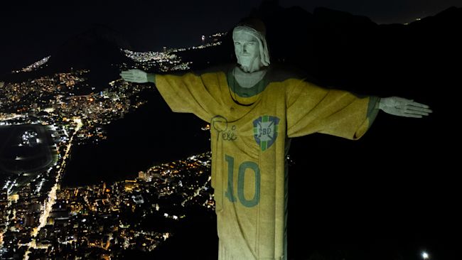 The Christ the Redeemer statue is illuminated with an image of Pele's Brazilian jersey.